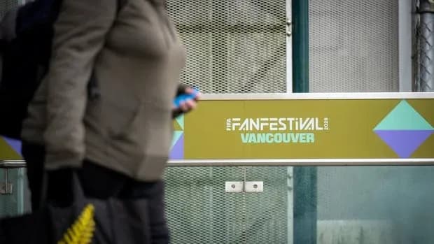 Persona caminando junto a cartel de Fan Festival Vancouver