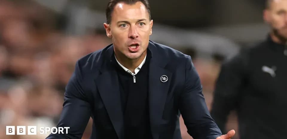 Entrenador gesticulando durante un partido de fútbol
