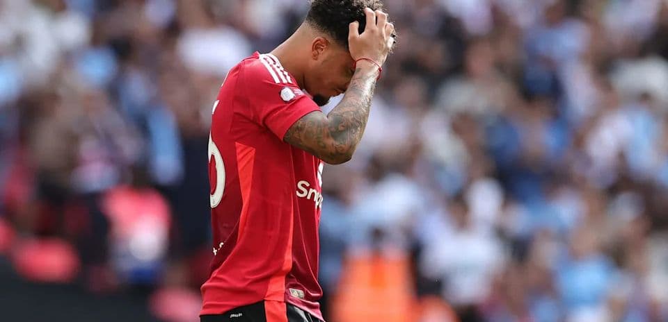 Jugador con camiseta roja se agarra la cabeza