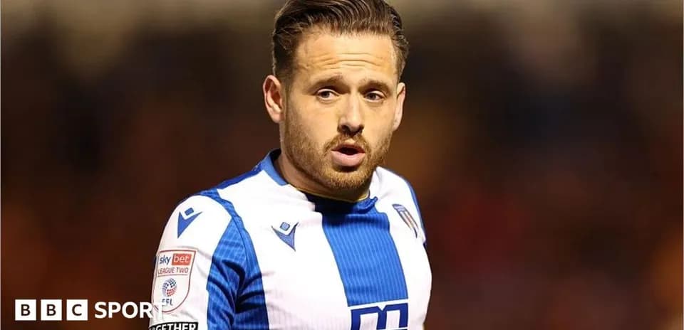 Jugador de fútbol con camiseta blanca y azul en acción