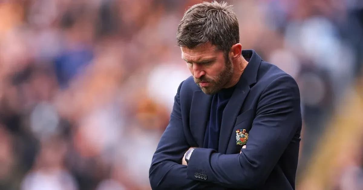 Entrenador mirando hacia abajo con los brazos cruzados