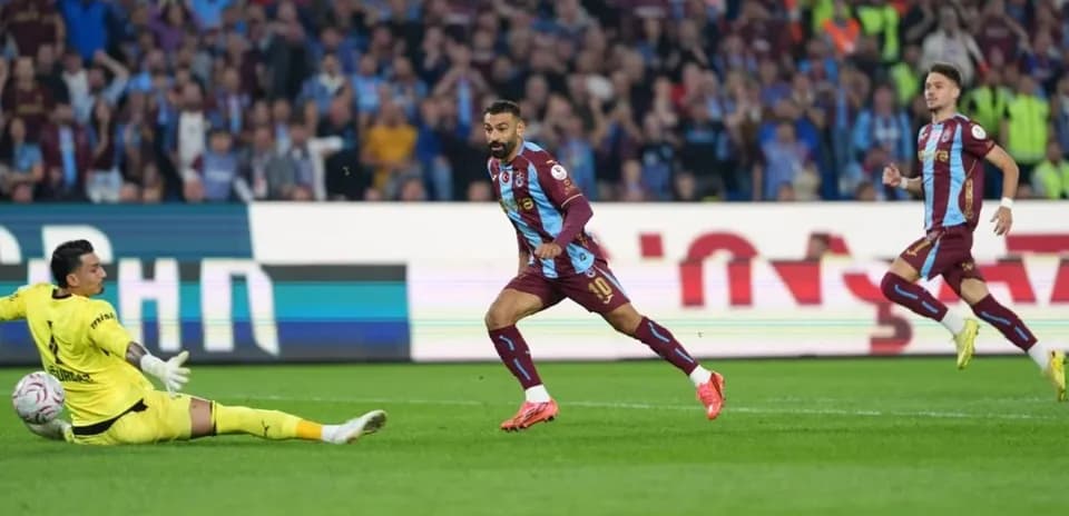 Jugador de Trabzonspor ante el portero rival en acción
