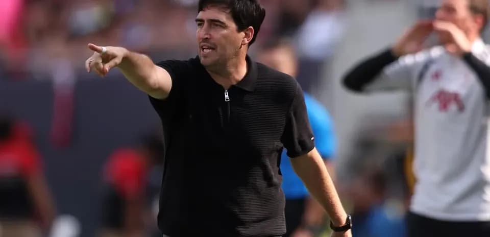 Entrenador dirigiendo al equipo desde la línea lateral