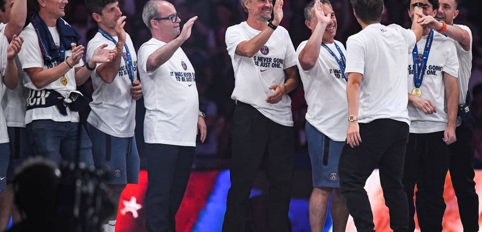 Equipo celebrando en el podio con camisetas blancas