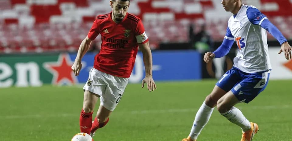Jugador de Benfica driblando a rival de Lech Poznan