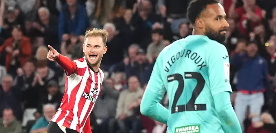 Jugador celebrando un gol mientras el portero observa