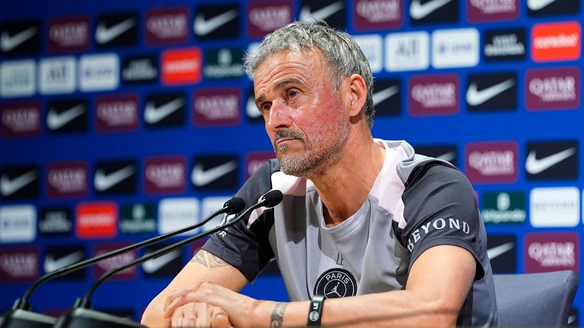 Entrenador en rueda de prensa con fondo de patrocinadores