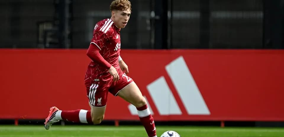 Jugador de Liverpool corriendo con el balón en el campo