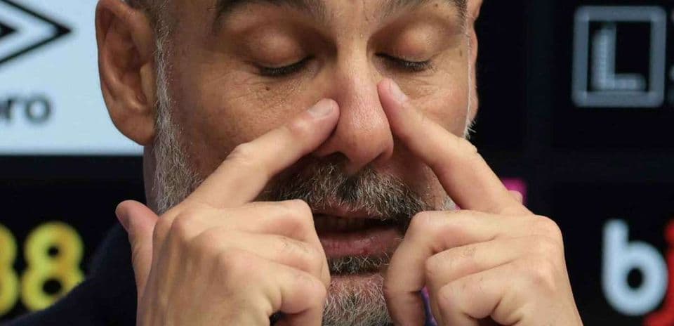 Entrenador tocando su cara durante una conferencia
