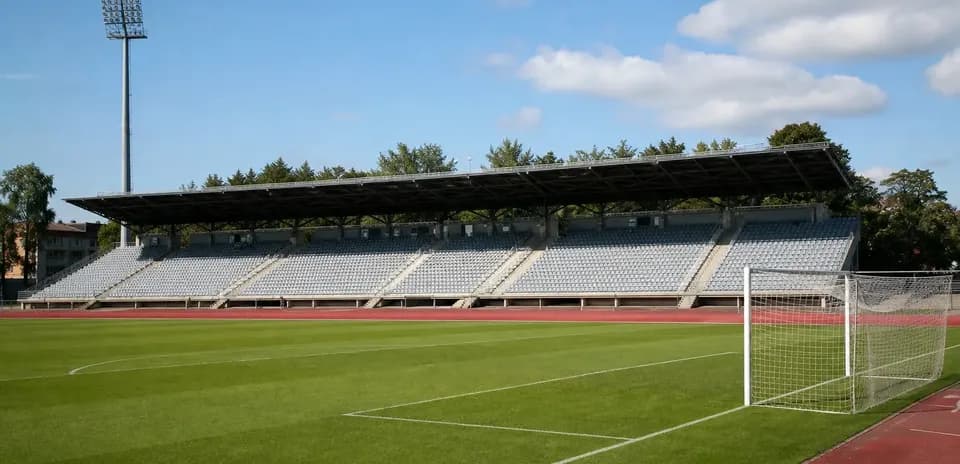 Estadio vacío con gradas y portería de fútbol