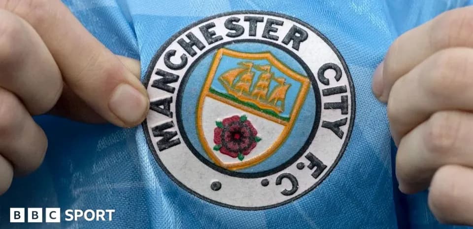 Persona señalando el escudo del Manchester City