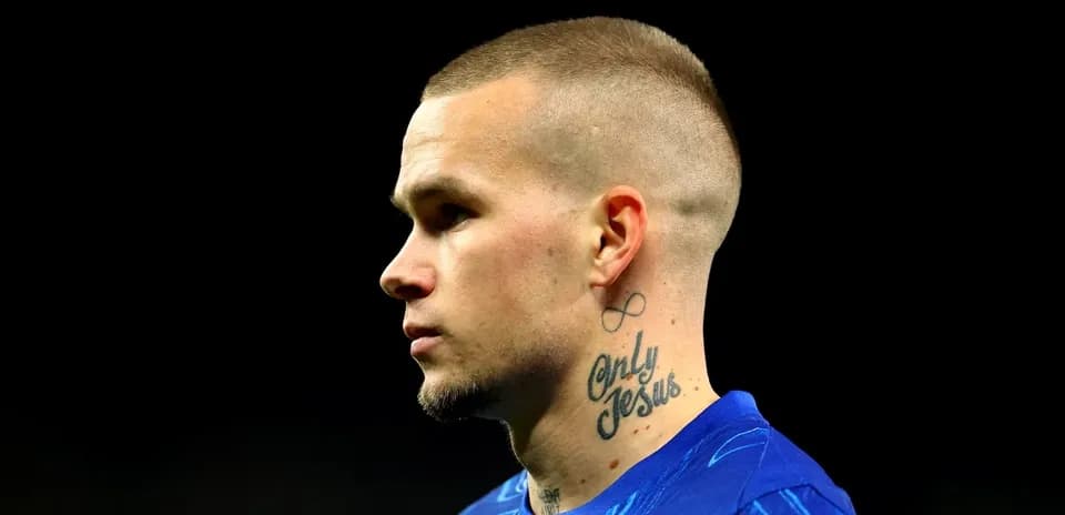 Jugador con camiseta azul y tatuajes en el cuello