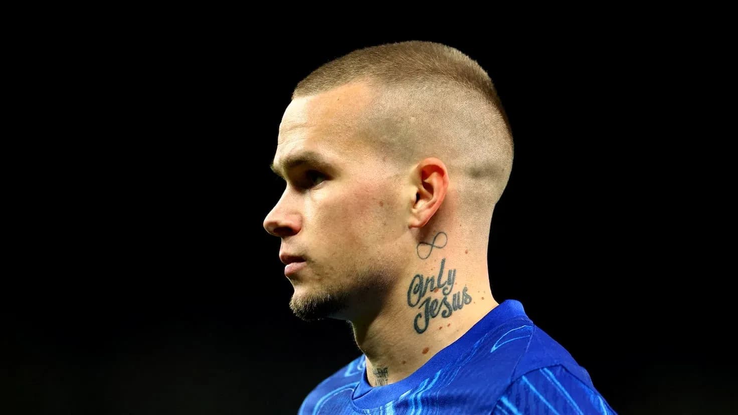 Jugador con camiseta azul y tatuajes en el cuello