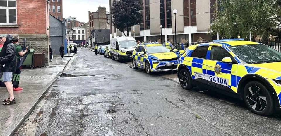 Vehículos de Garda estacionados en una calle lluviosa