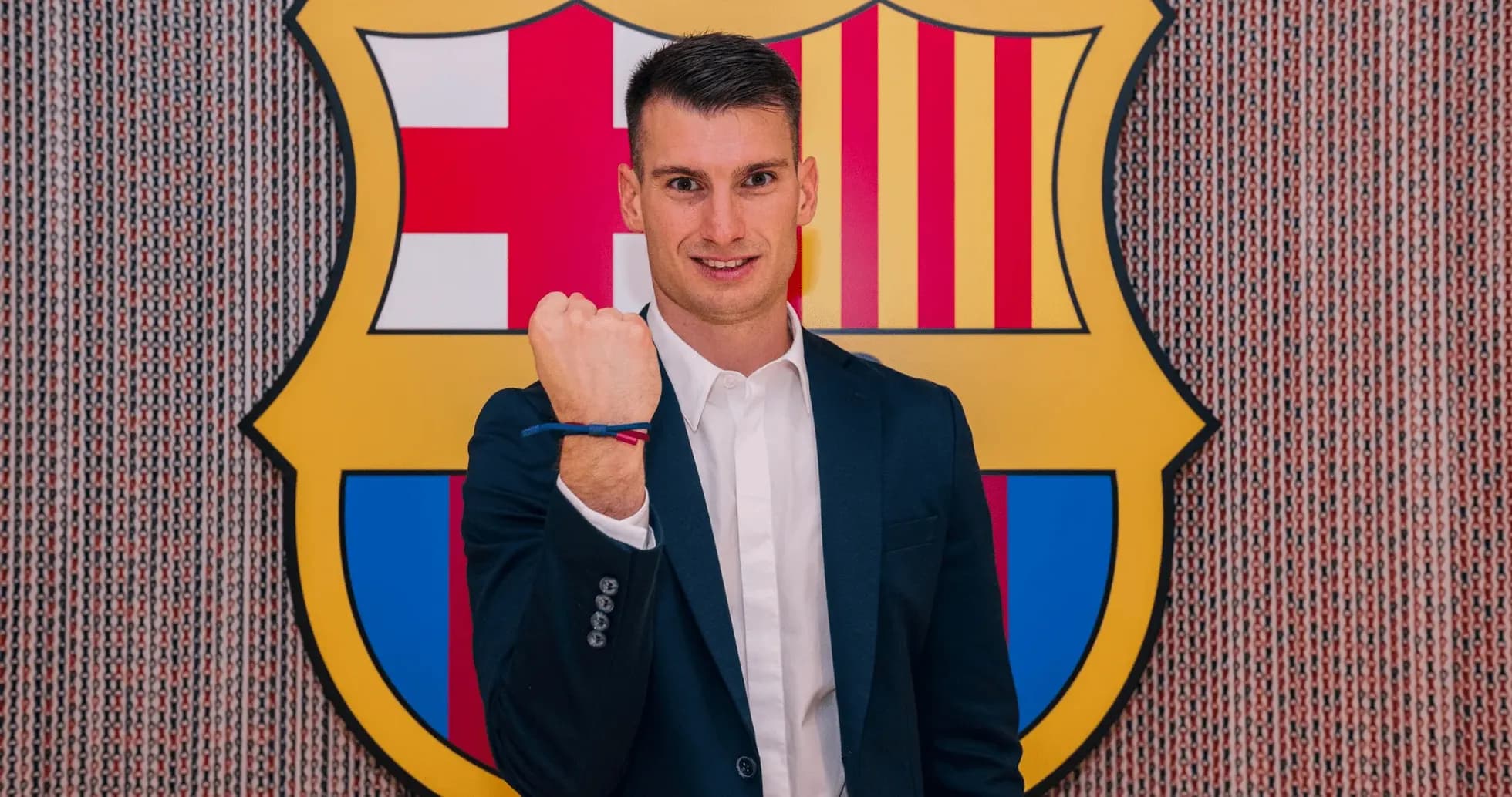 Jugador posando frente al escudo del FC Barcelona