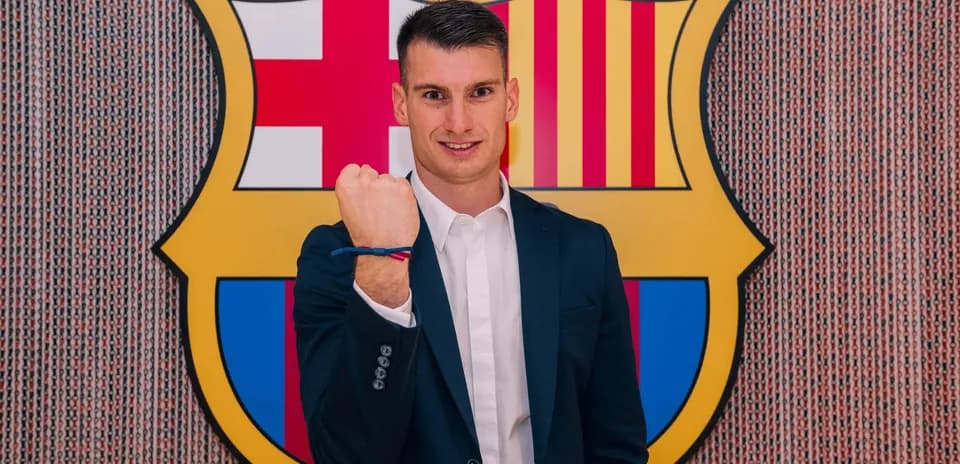 Jugador posando frente al escudo del FC Barcelona
