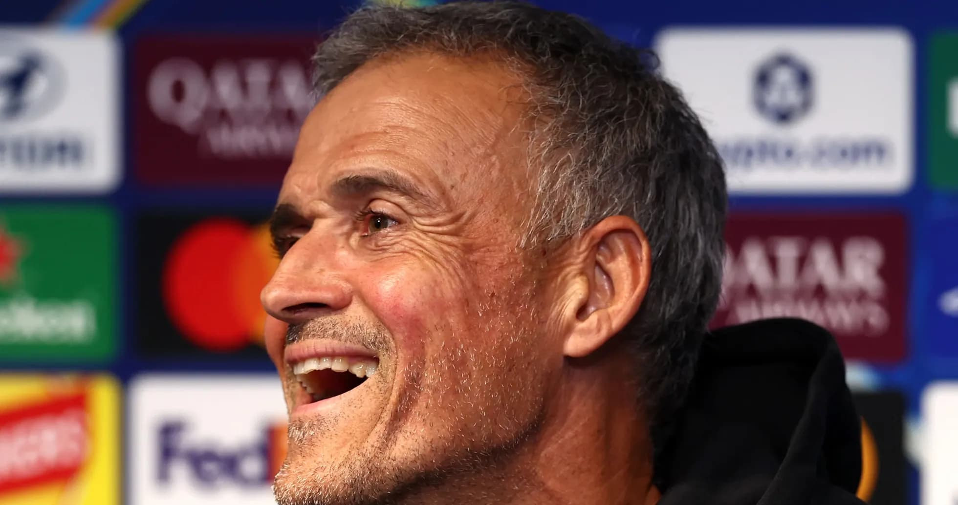 Entrenador sonriendo en conferencia de prensa
