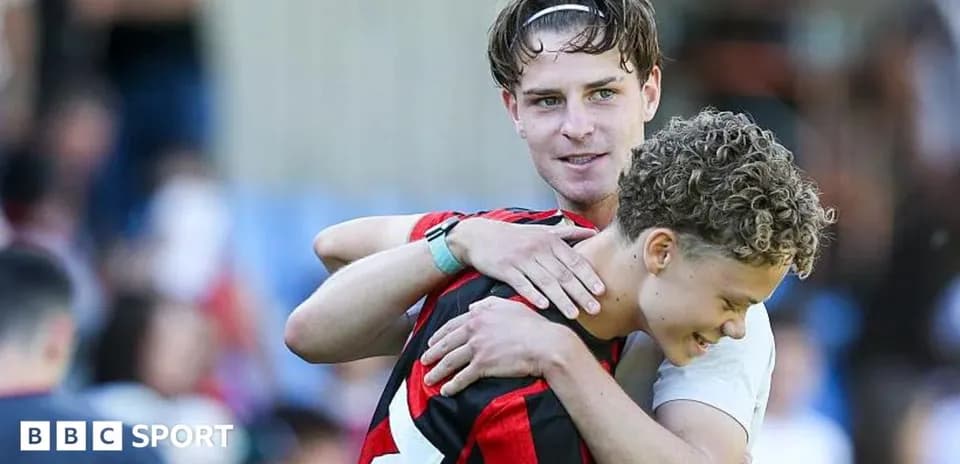 Dos jugadores abrazándose en el campo de fútbol
