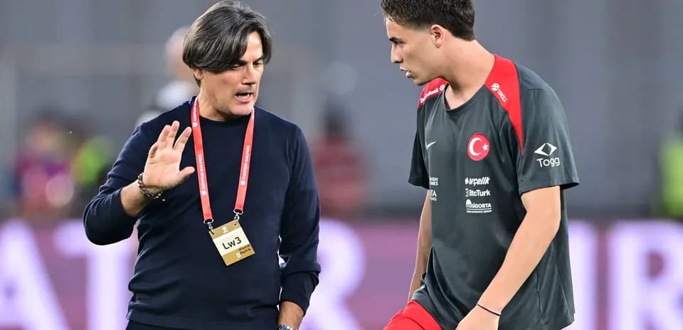 Entrenador hablando con jugador en campo de entrenamiento