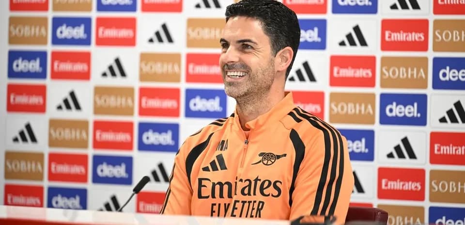 Entrenador en conferencia de prensa sonriente