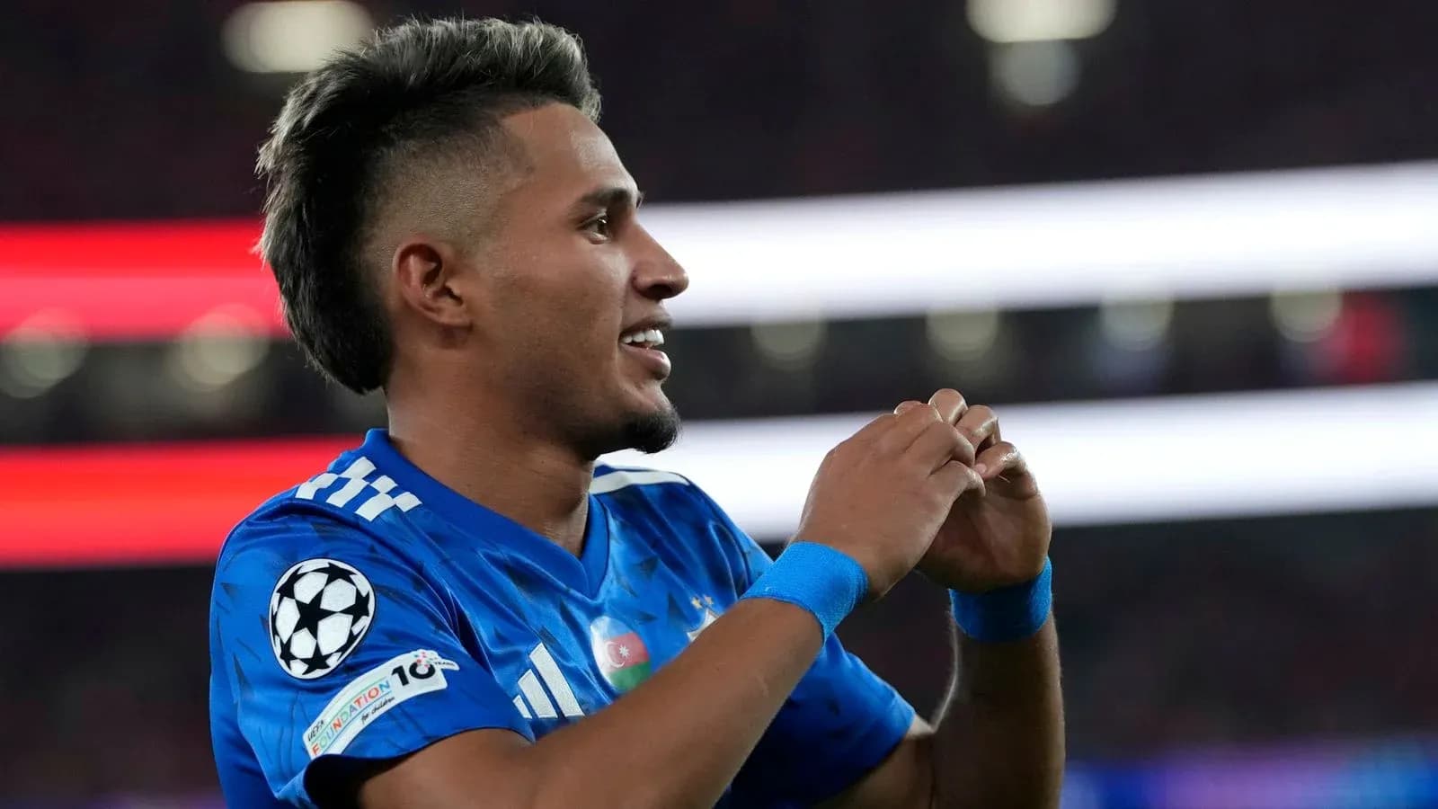 Jugador celebrando con camiseta azul durante partido