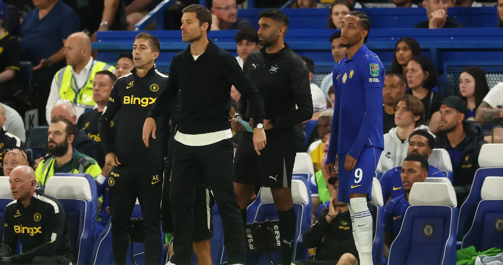 Entrenadores y jugador en la banca durante el partido