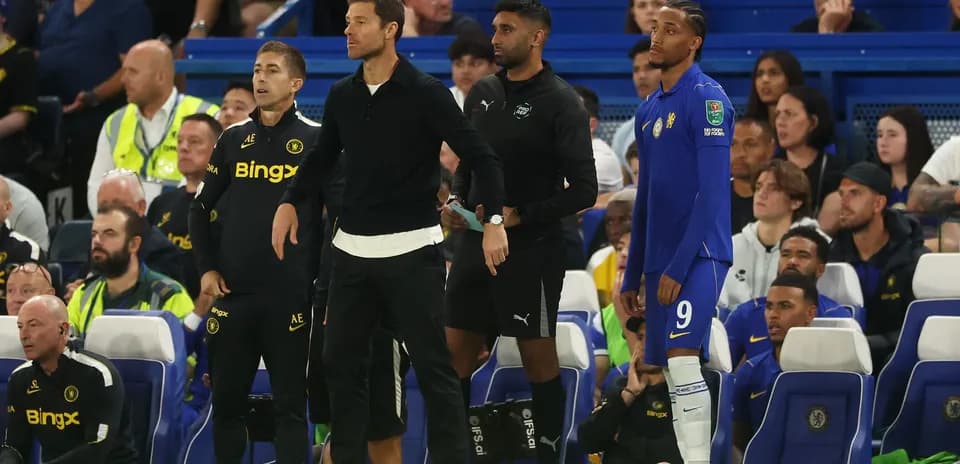 Entrenadores y jugador en la banca durante el partido