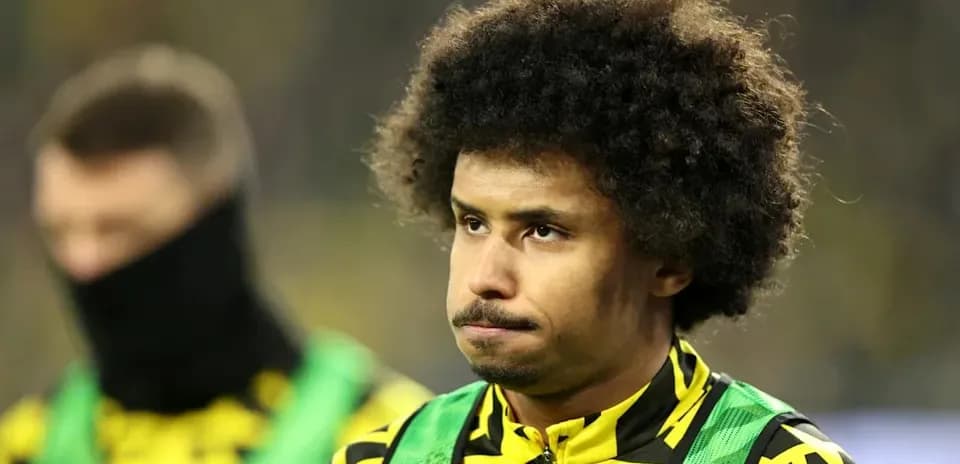 Jugador en el banquillo con uniforme amarillo y verde