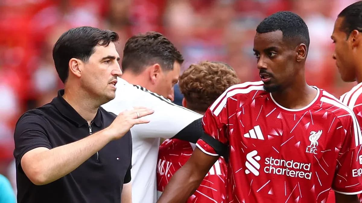 Entrenador hablando con jugador de Liverpool en el banquillo