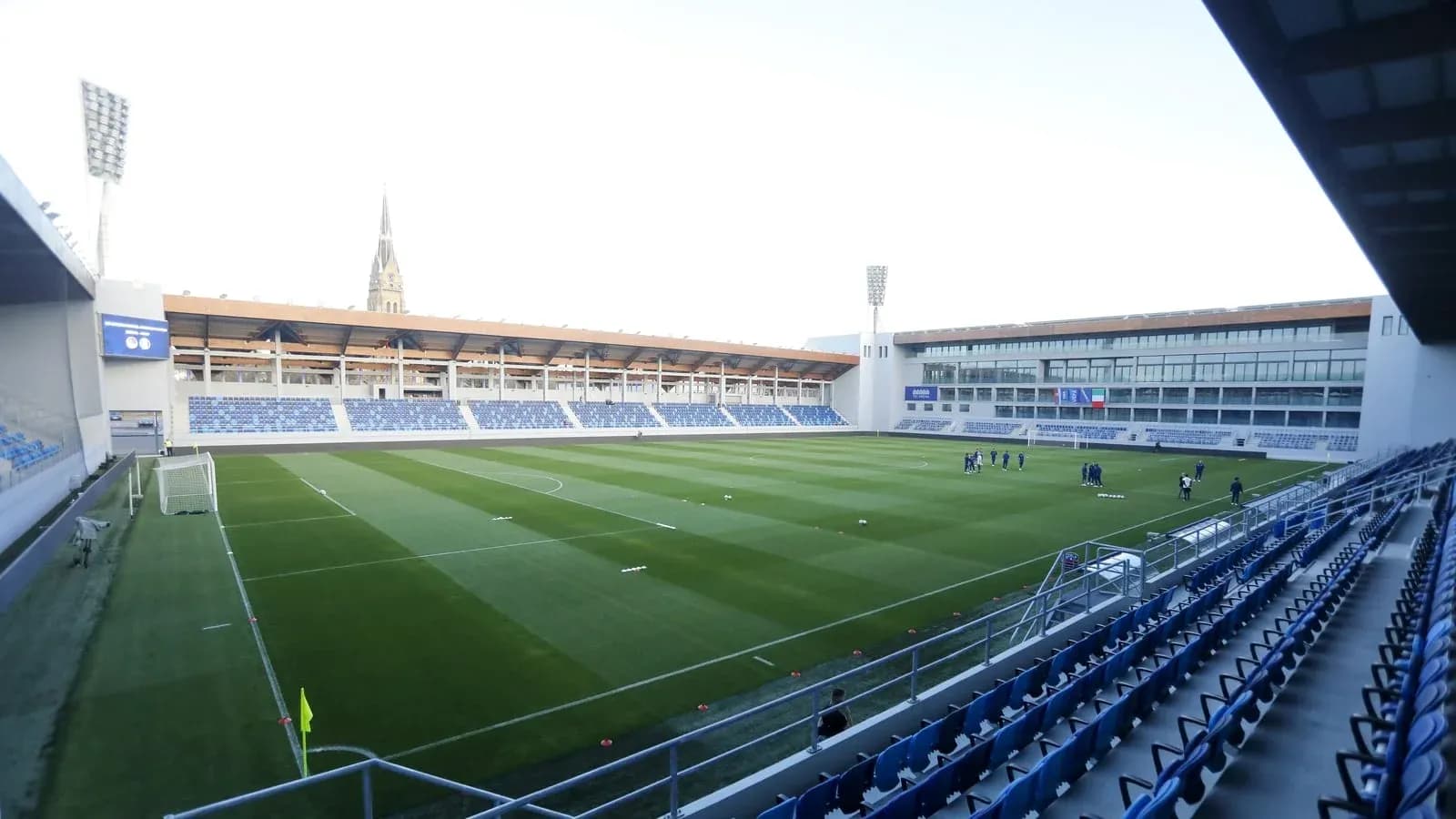 Estadio vacío con jugadores en entrenamiento en campo