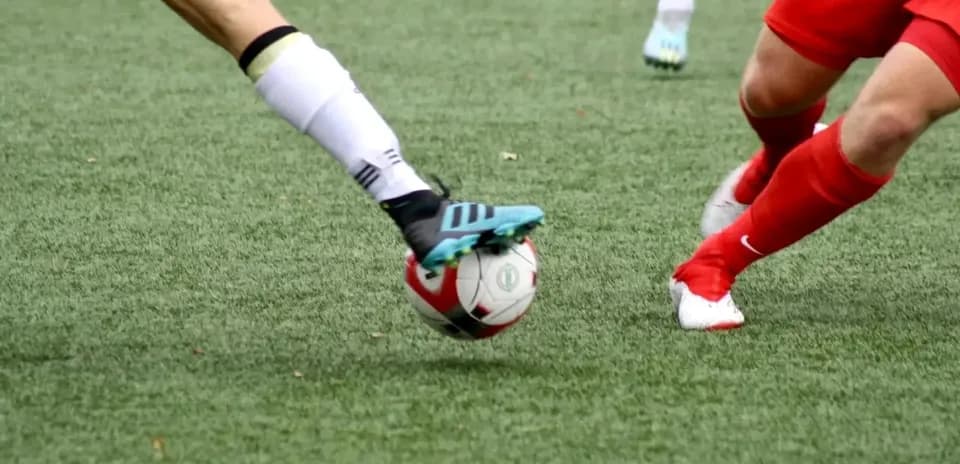 Jugadoras compitiendo por el balón en fútbol