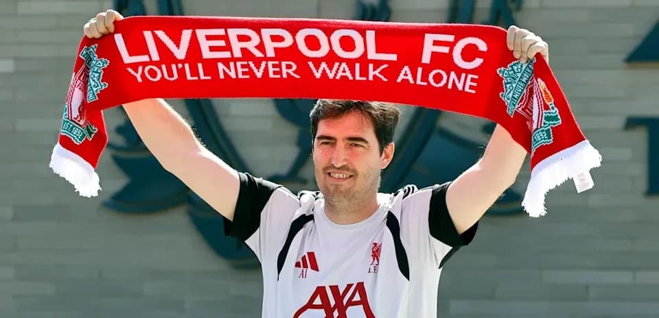Jugador sosteniendo una bufanda de Liverpool FC