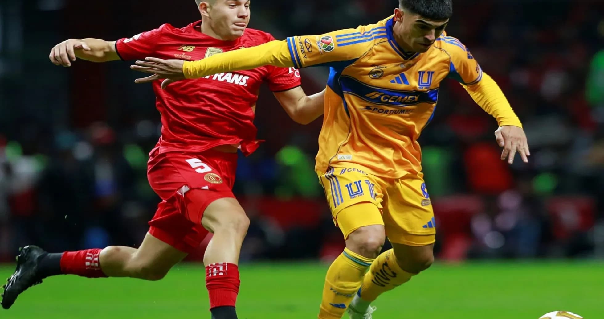 Jugadores de Toluca y Tigres compiten por el balón