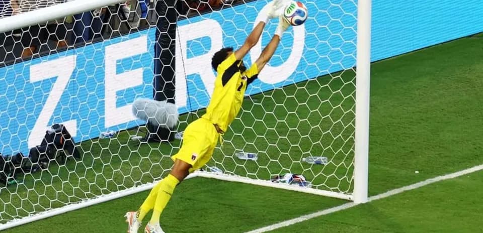 Portero saltando para detener un tiro en el gol