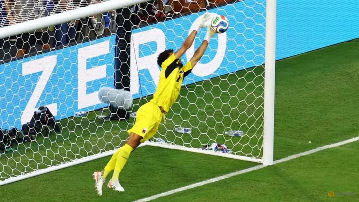 Portero saltando para detener un tiro en el gol