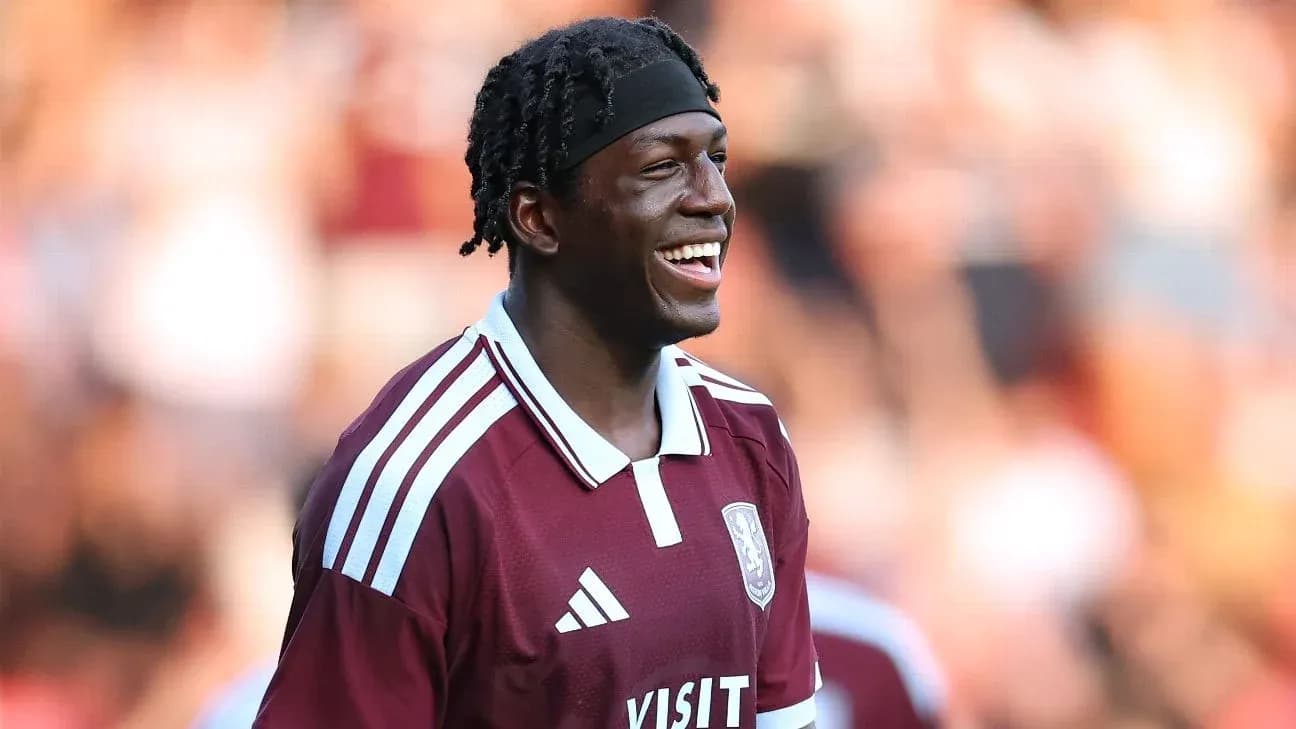 Jugador sonriendo con camiseta granate en el campo