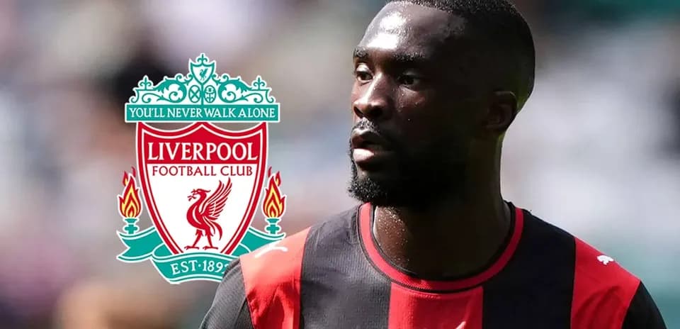 Jugador en uniforme con logo de Liverpool de fondo