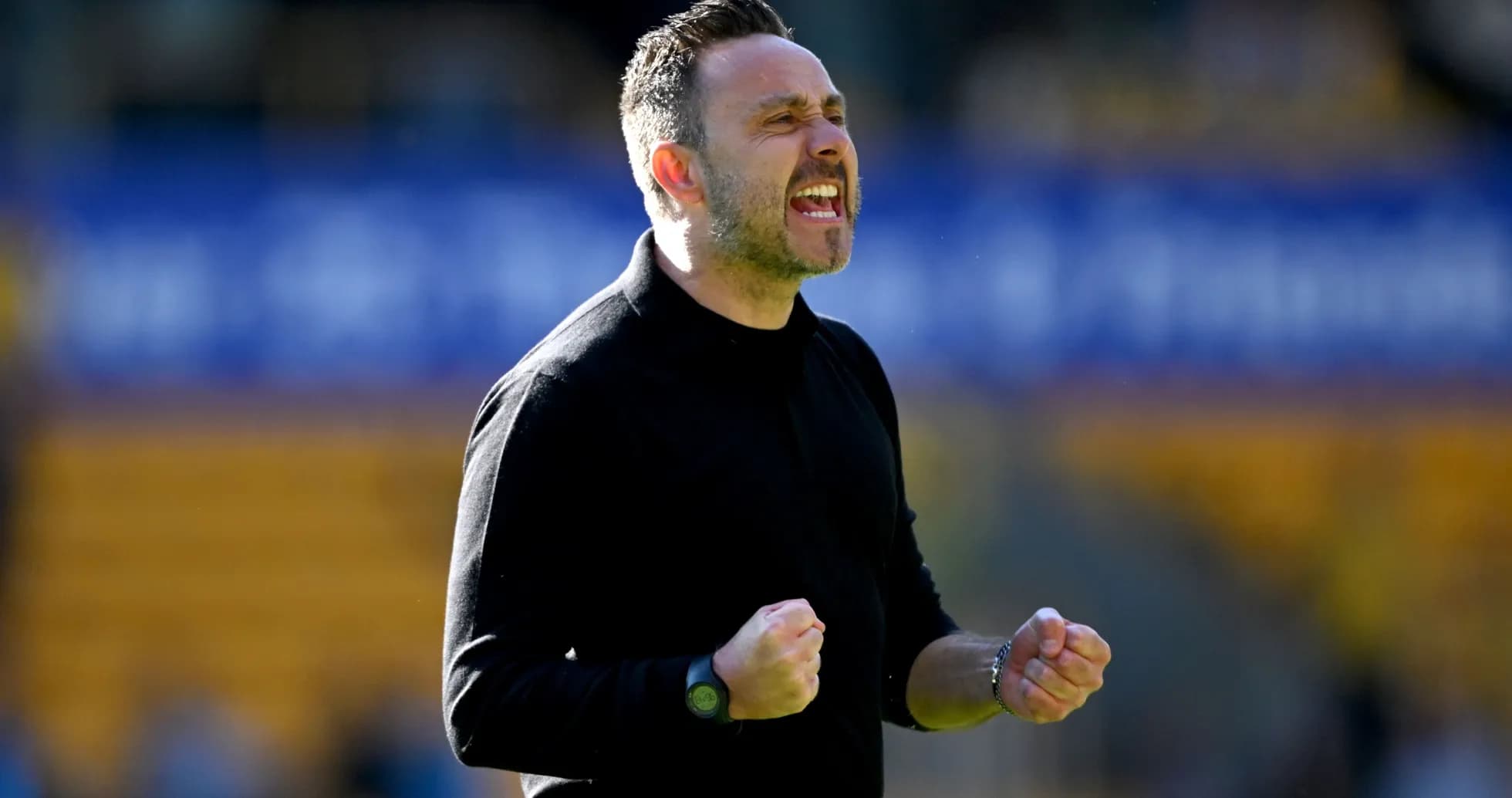 Entrenador celebrando con puños cerrados en el campo
