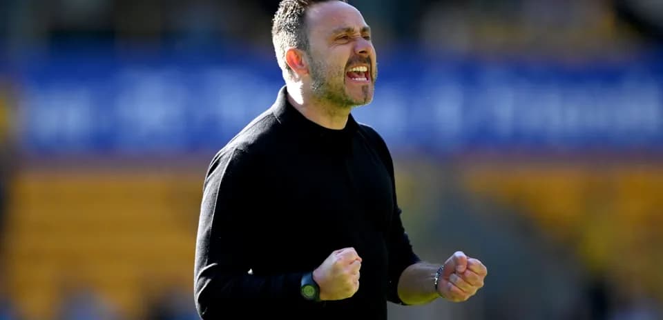 Entrenador celebrando con puños cerrados en el campo