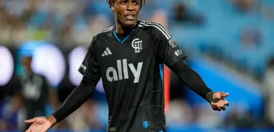 Jugador en uniforme negro gesticulando en el campo