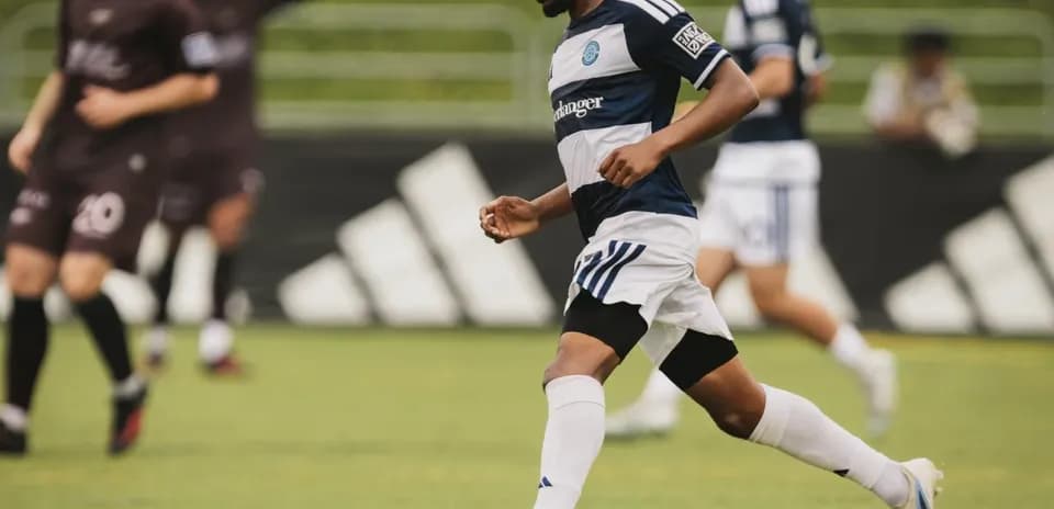 Jugador corriendo con el balón en el campo