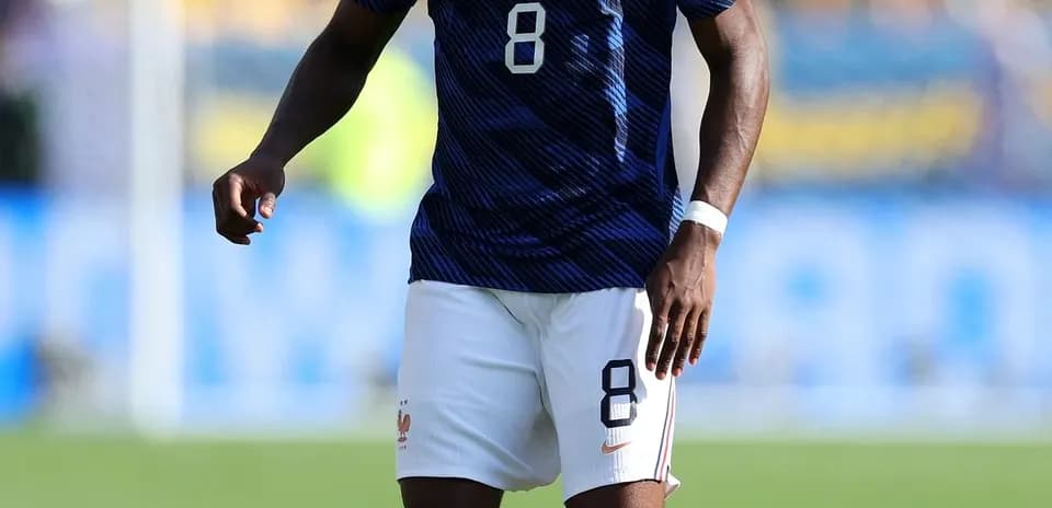 Jugador de Francia con balón en campo de fútbol