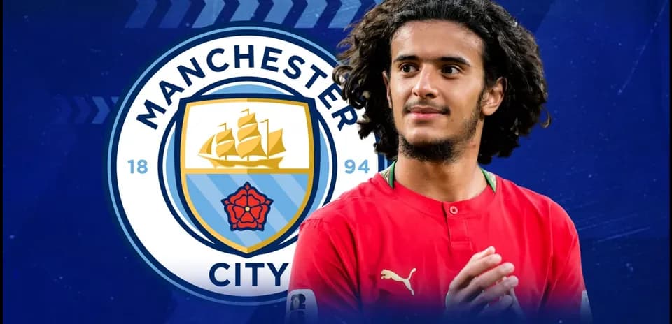 Jugador con camiseta roja frente al escudo de Manchester City