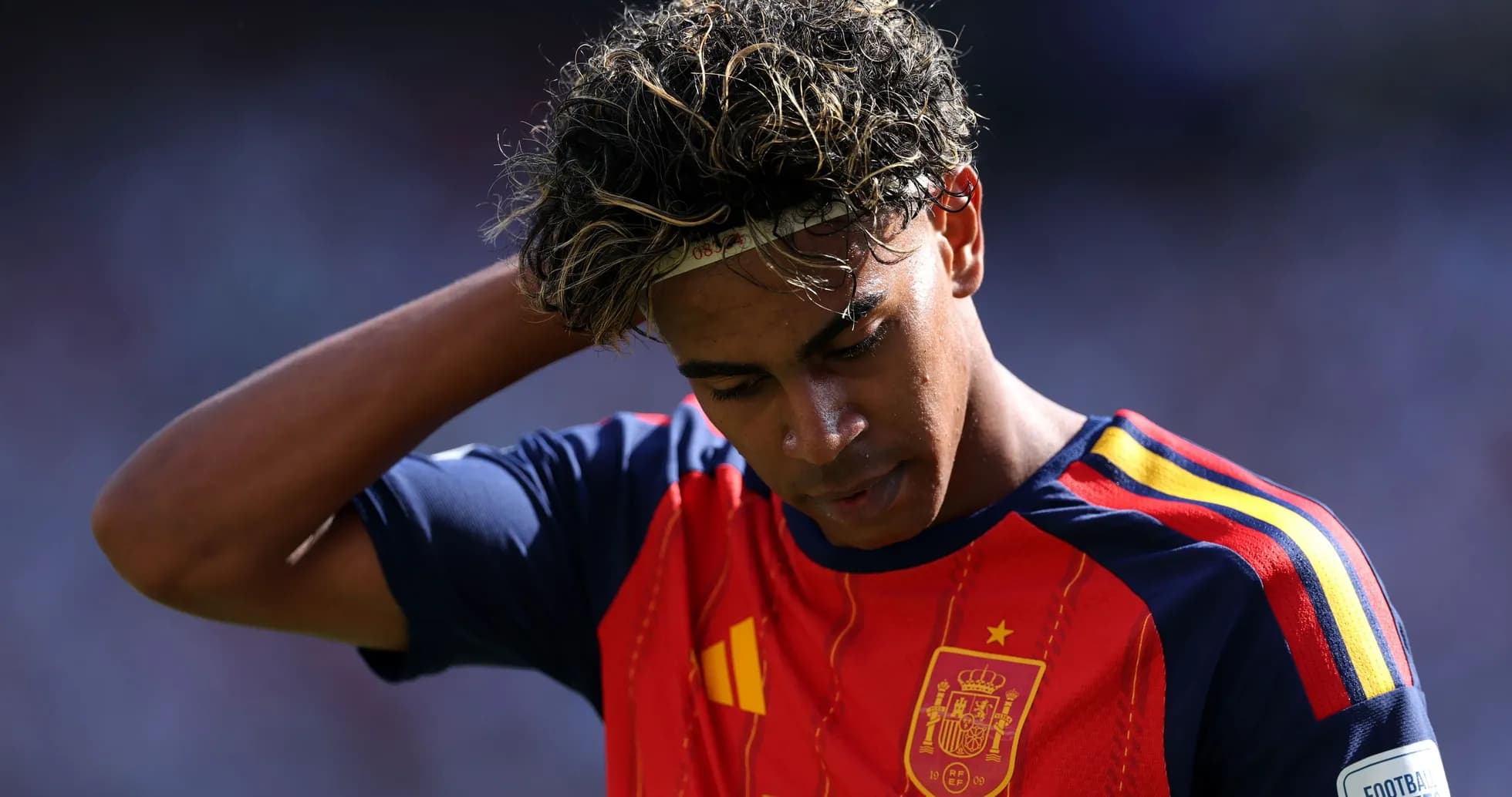 Jugador de España con camiseta roja mirando hacia abajo