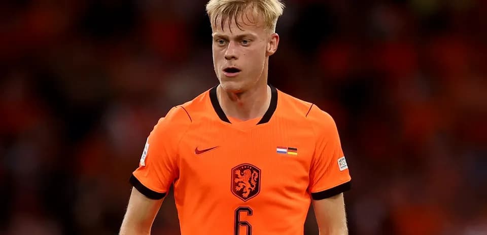 Jugador de fútbol con camiseta naranja en el campo