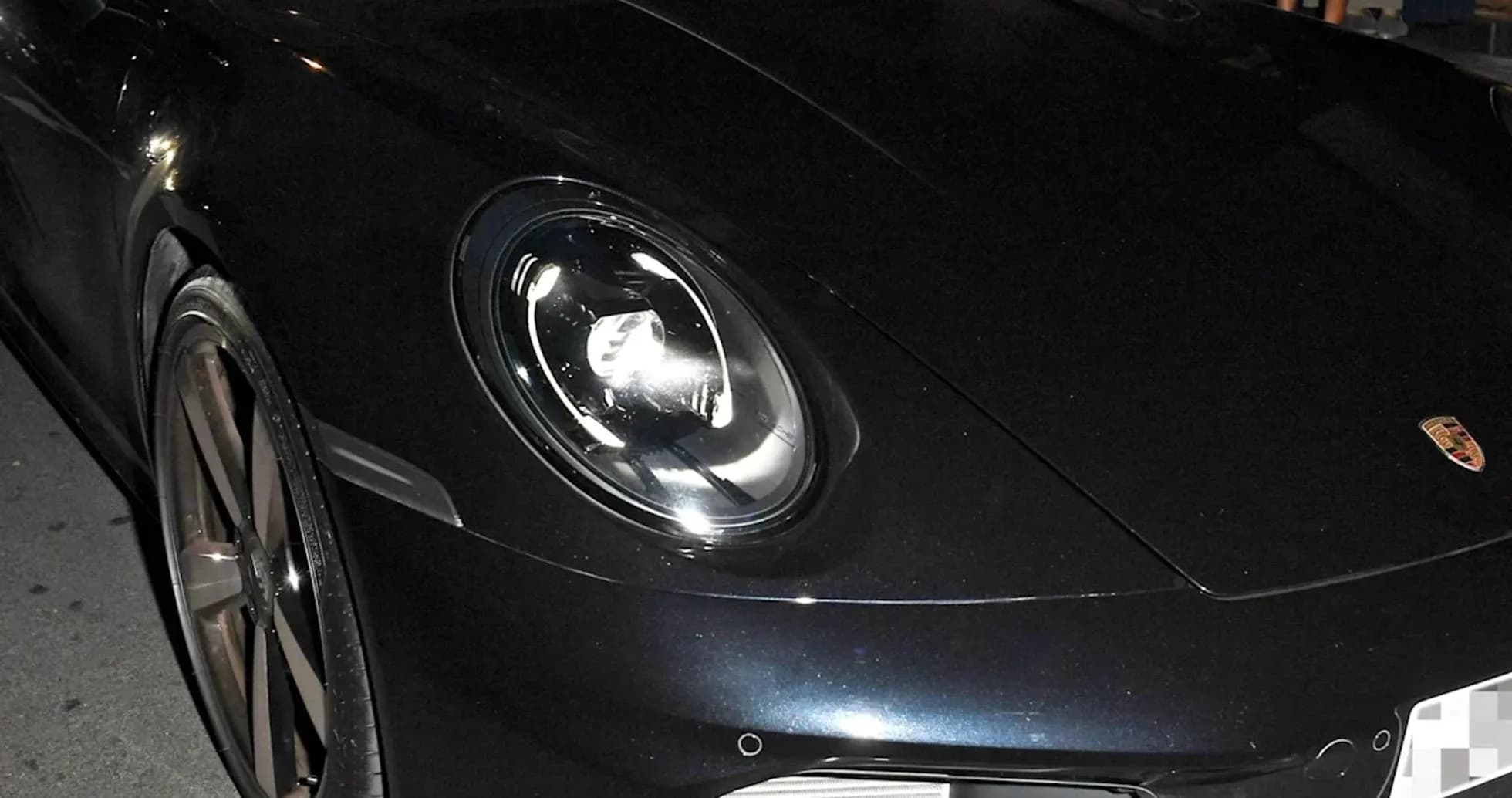 Dos hombres en un Porsche negro estacionado