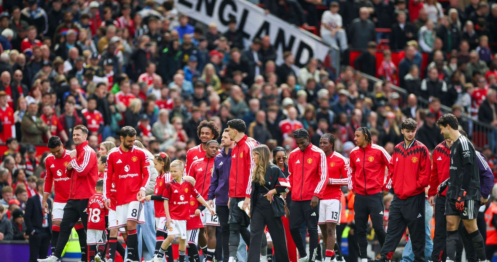 Jugadores de Manchester United en el campo con aficionados