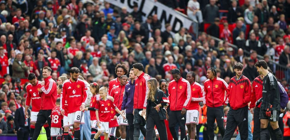 Jugadores de Manchester United en el campo con aficionados