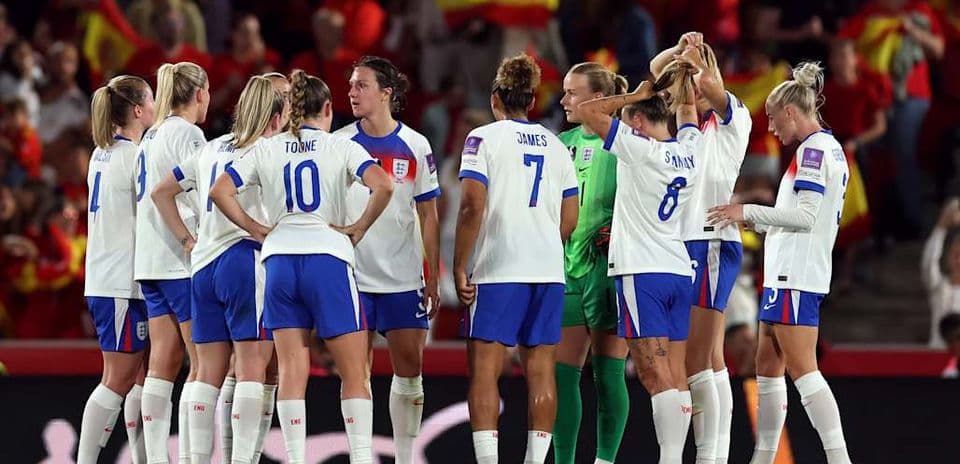 Jugadoras de Inglaterra reunidas en el campo durante partido