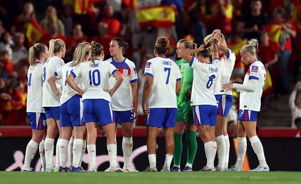 Jugadoras de Inglaterra reunidas en el campo durante partido